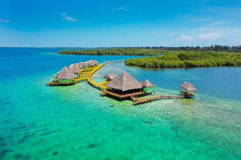 Aerial view of the lodge's palafitos and walkway over turquoise water