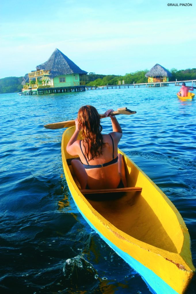 Guest paddling a yellow kayak near the palafitos