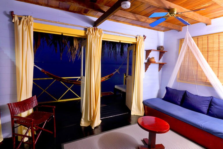 Palafito living area with blue sofas and a view of the terrace