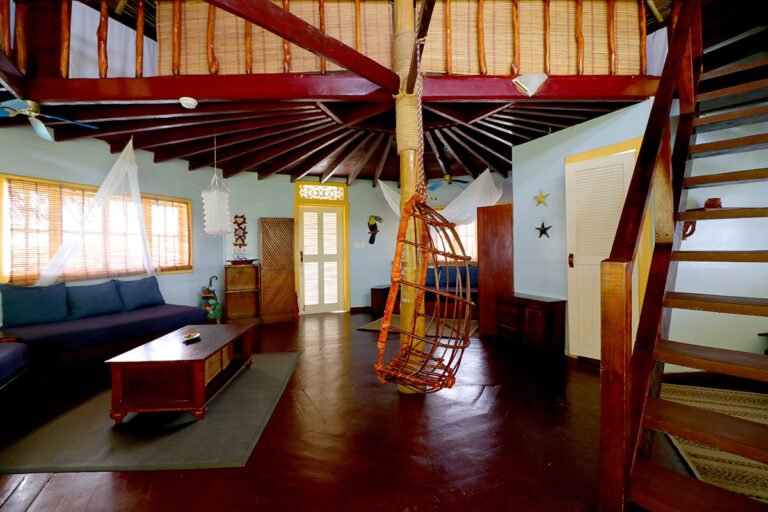 Spacious palafito living room with wooden floors and a staircase