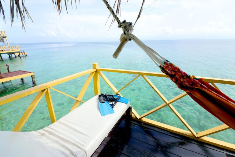 Hammock and lounger on a palafito terrace above turquoise water
