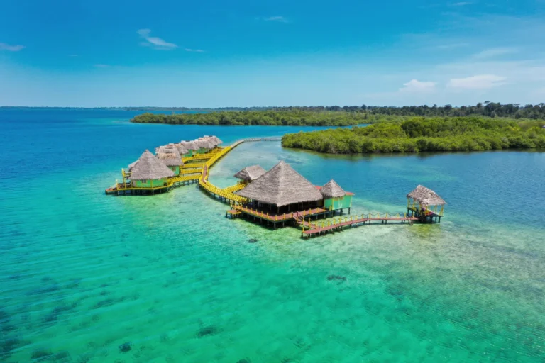 Aerial view of the lodge's palafitos and walkway over turquoise water