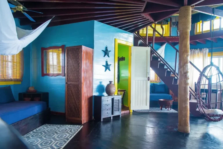 Inside a palafito: wooden stairs, blue and green walls and natural light